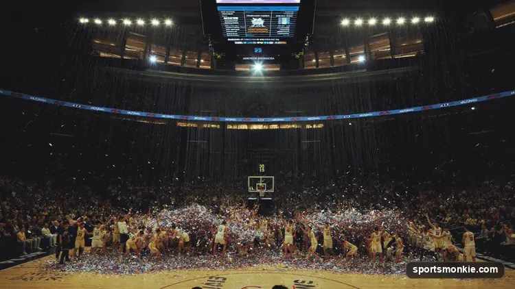 Basketball going through the hoop with net motion under bright arena lighting