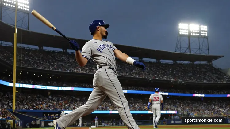 MLB batter making contact at home plate under stadium lights