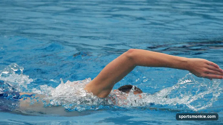 Swimmer performing backstroke swimming technique with an alternating straight-arm recovery in a competition pool