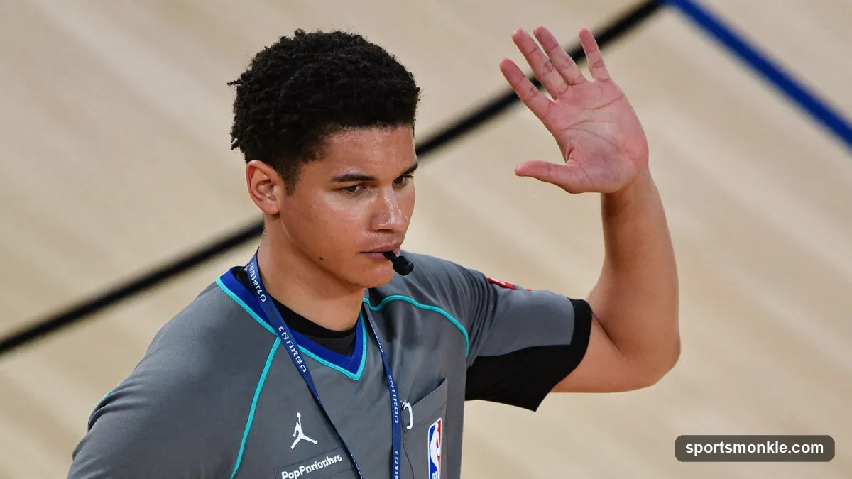 Basketball referee demonstrating hand signals for fouls and violations on the court