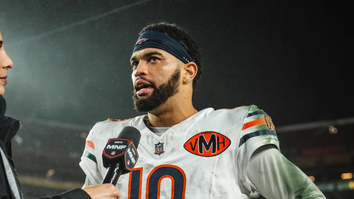File photo from 13 October 2025: Caleb Williams in his Bears No. 18 jersey answering questions in a postgame television interview at Washington, a year before this press conference. It does not show the Minnesota game or Thursday's media session. The 16:9 cropped derivative is offered under the same CC BY-SA 4.0 licence.