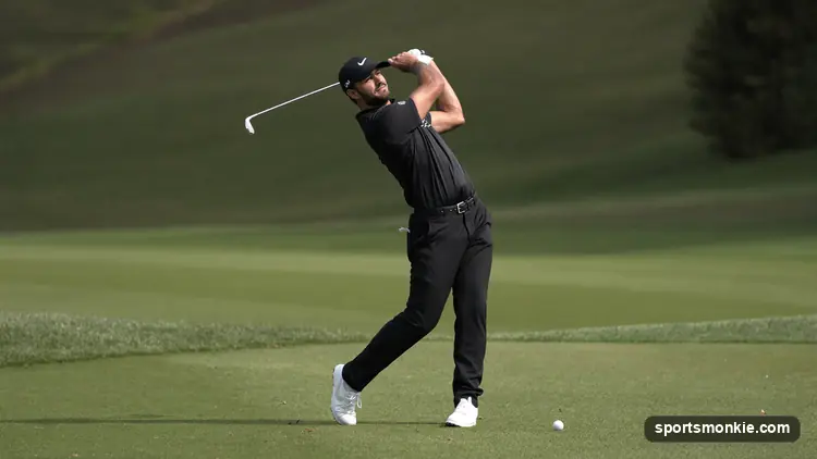 Golfer mid-downswing on the range, hips driving toward the ball during an iron shot