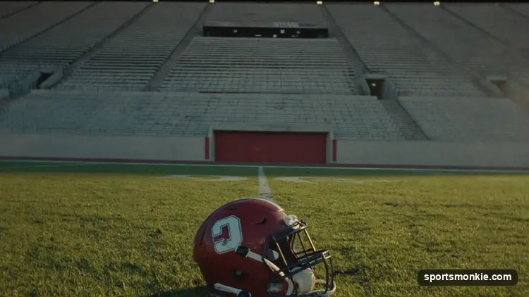 American football on a chalk yard line under bright stadium lights