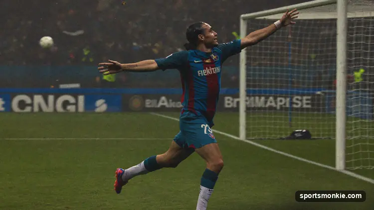 Football player celebrating a goal in front of a packed stadium