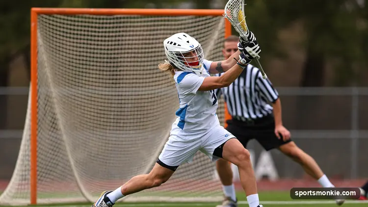 A lacrosse player winding up for a hard overhand shot on goal during a game
