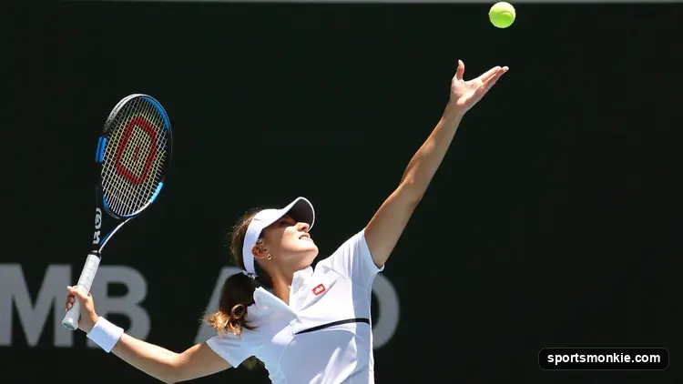 A tennis player launching into a powerful serve on a hard court