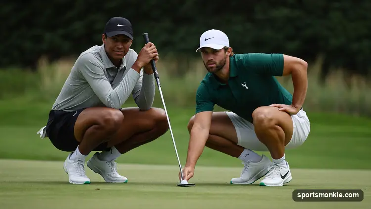 Two golfers reading a putt together on a Ryder Cup-style green