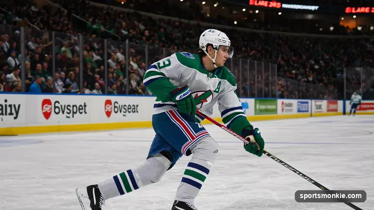 NHL player skating with the puck under arena lights