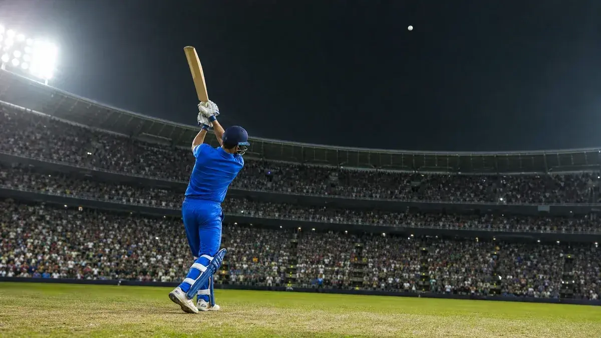 A cricket batter celebrating a big six in a T20 international match