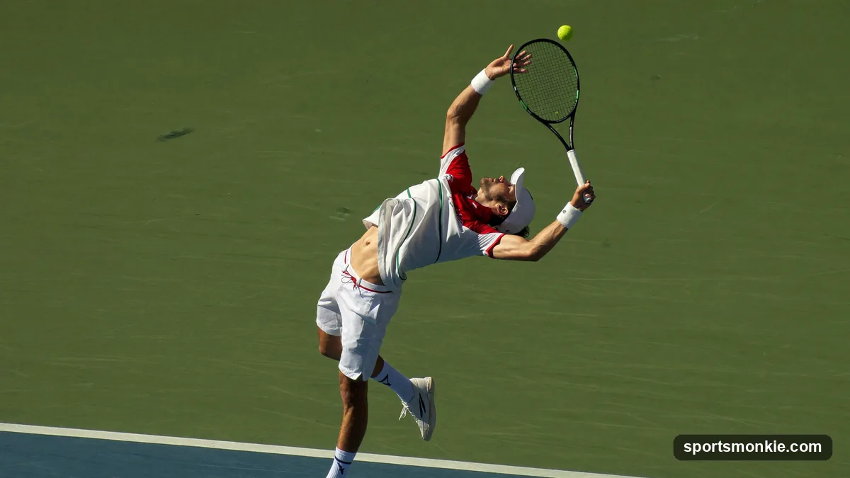 A tennis player arching back to brush up the back of the ball on a kick serve