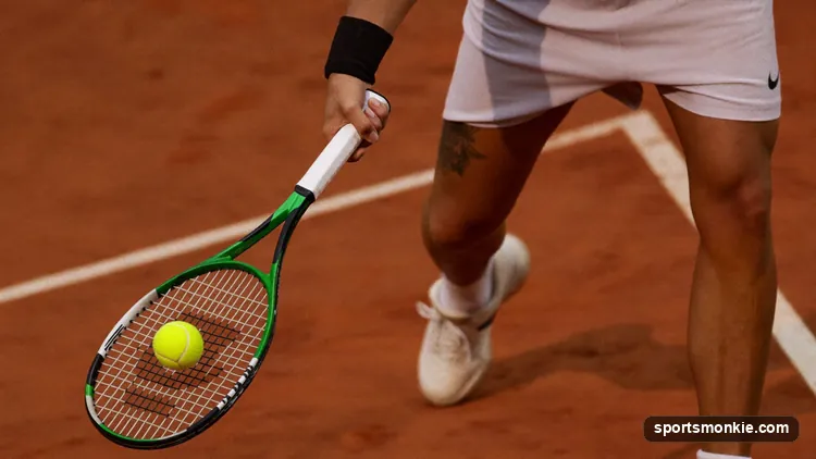 A tennis player swinging low-to-high and brushing up the back of the ball to generate topspin