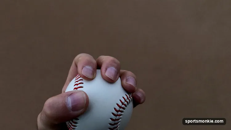 Close-up of a pitcher's hand gripping a baseball for a curveball