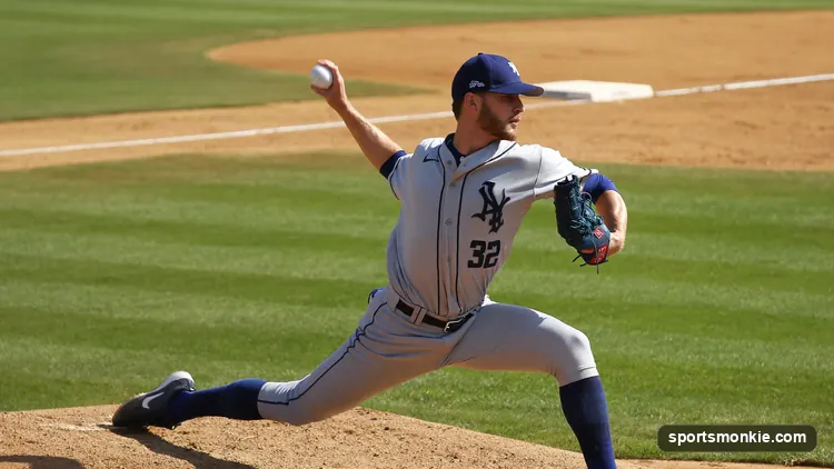 Close-up of a pitcher's hand gripping a baseball across the four-seam horseshoe seams before release
