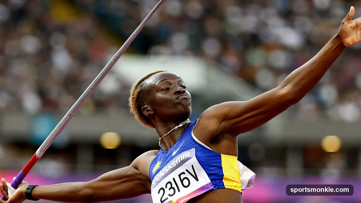 A javelin thrower mid-delivery on the runway, arm cocked back with the javelin pointed skyward before release