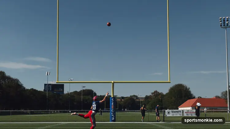 A placekicker striking a football through the uprights in a stadium