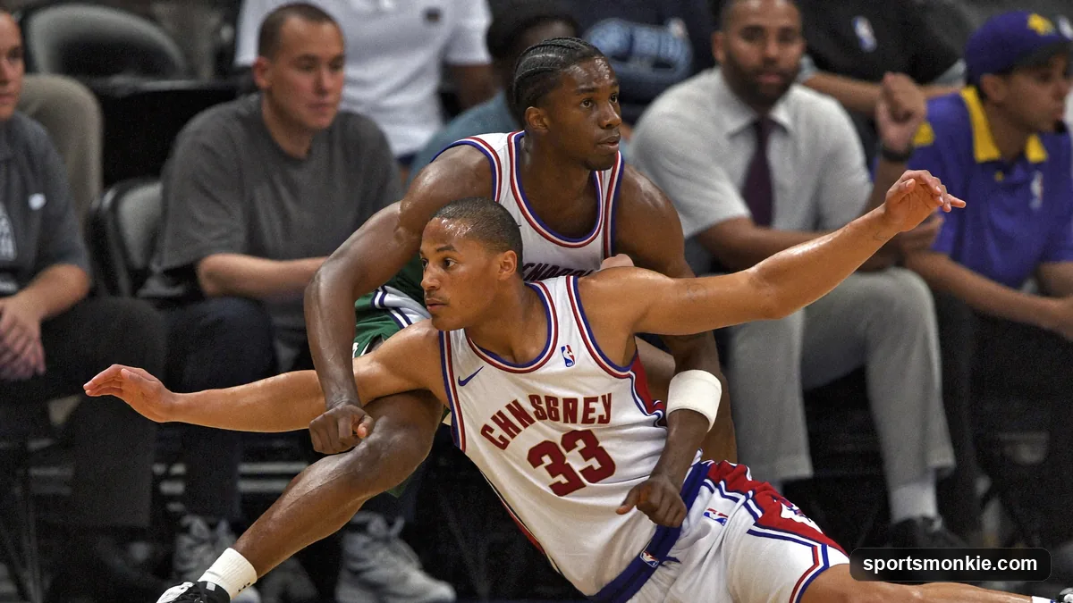 Basketball defender in a low, wide stance guarding a ball handler one-on-one during man-to-man defense