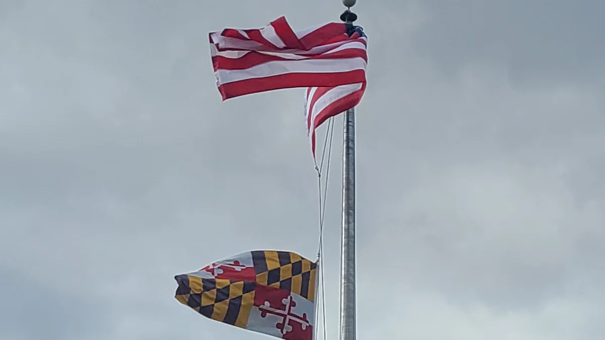 File photo from December 2023: the Maryland state flag, with its red and white Crossland quarters, flying below the United States flag. The altered version of this flag inside the tournament document is what the story is about. The cropped derivative is offered under the same CC BY-SA 4.0 licence.