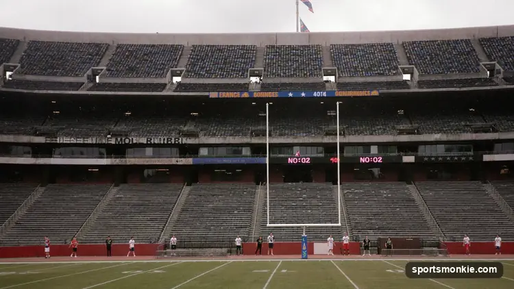 A weathered NFL helmet resting on an empty bench in a quiet stadium
