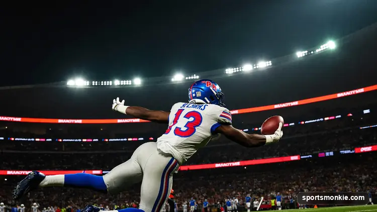 NFL wide receiver making a leaping catch downfield in front of a defender