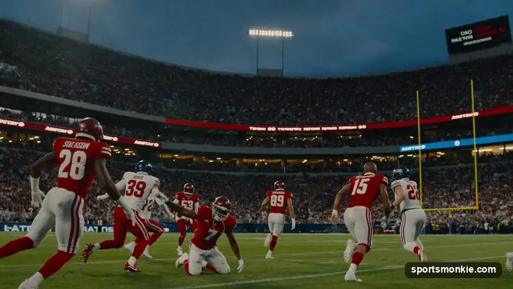 An NFL offense breaking a long run past defenders under stadium lights