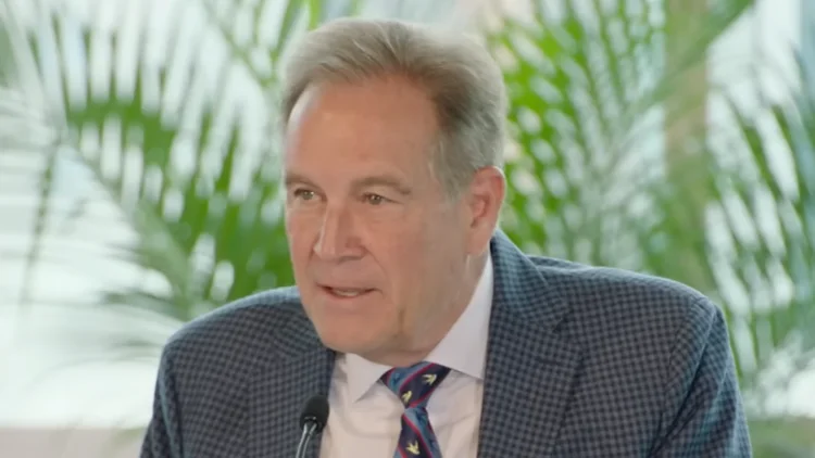 File photo from May 2026 of Jim Nantz speaking at a podium. It does not show Sunday's CBS broadcast or the punch. The 16:9 cropped derivative is offered under the same CC BY 4.0 licence.