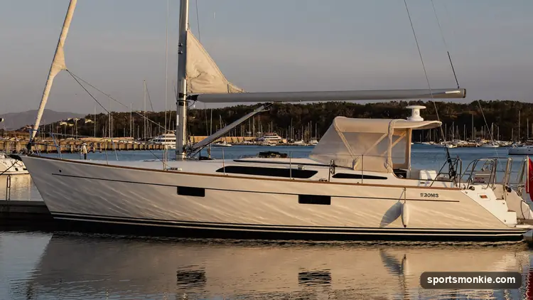 A marine surveyor inspecting the hull of a sailboat hauled out of the water on stands