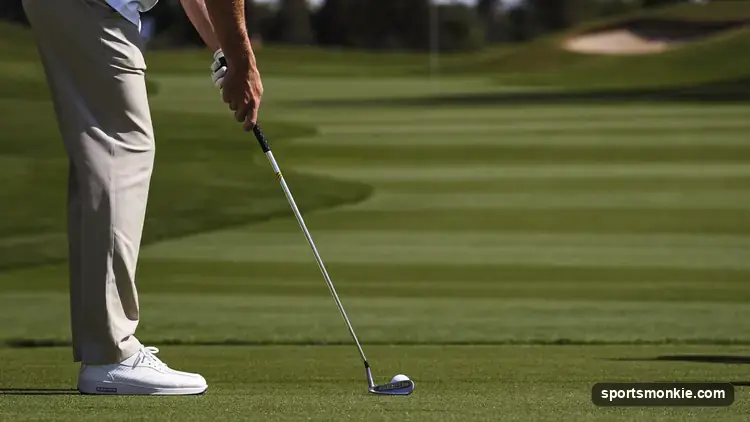 A golfer at address with the club shaft and lead arm forming a single straight line