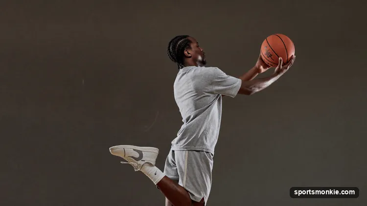 Guard rising into a balanced catch-and-shoot three-pointer with feet set behind the arc