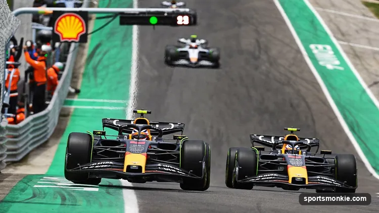 A Formula 1 car entering the pit lane while a rival stays out on track, illustrating pit strategy