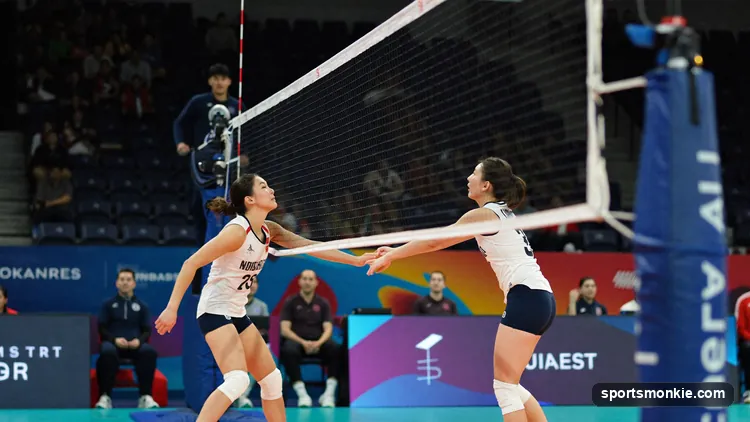 Indoor volleyball match in play with six players a side and the net between the teams