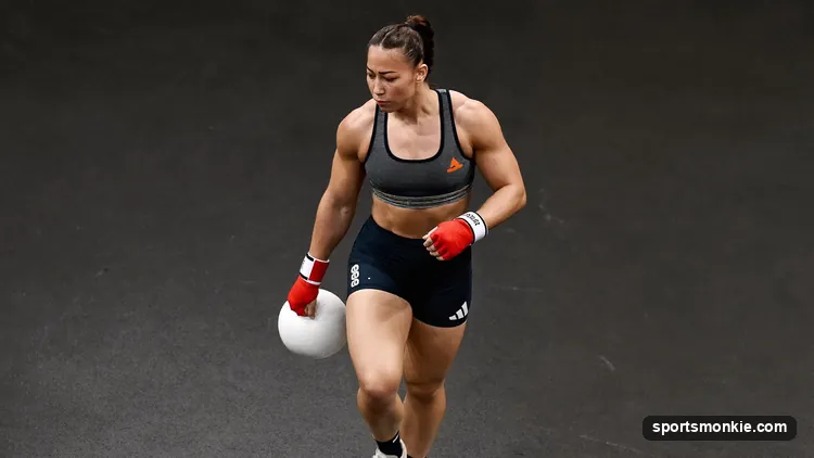 A fighter in a sweat suit stepping on a scale at a weigh-in