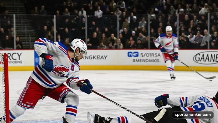Hockey player cross-checking an opponent with both hands on the stick shaft in front of the net