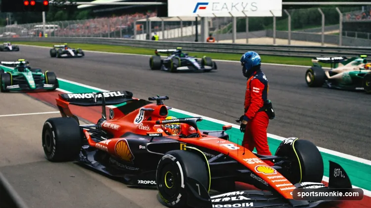 Formula 1 car stopped at the side of the track with a marshal attending as the race continues