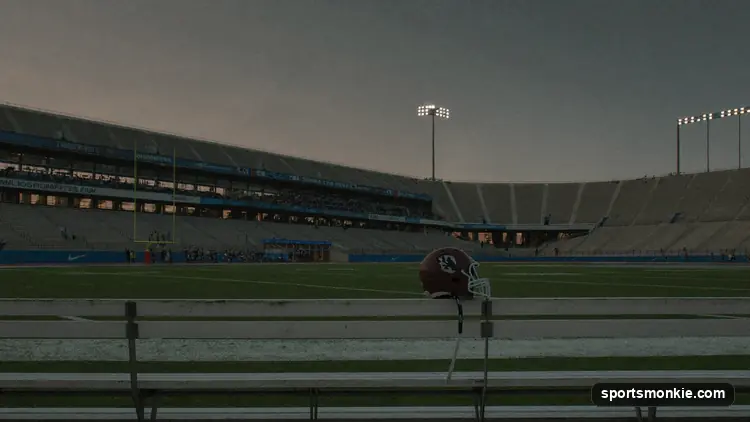 Empty American football stadium under grey skies with an unlit scoreboard