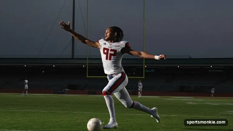 College football player running with the ball under stadium lights